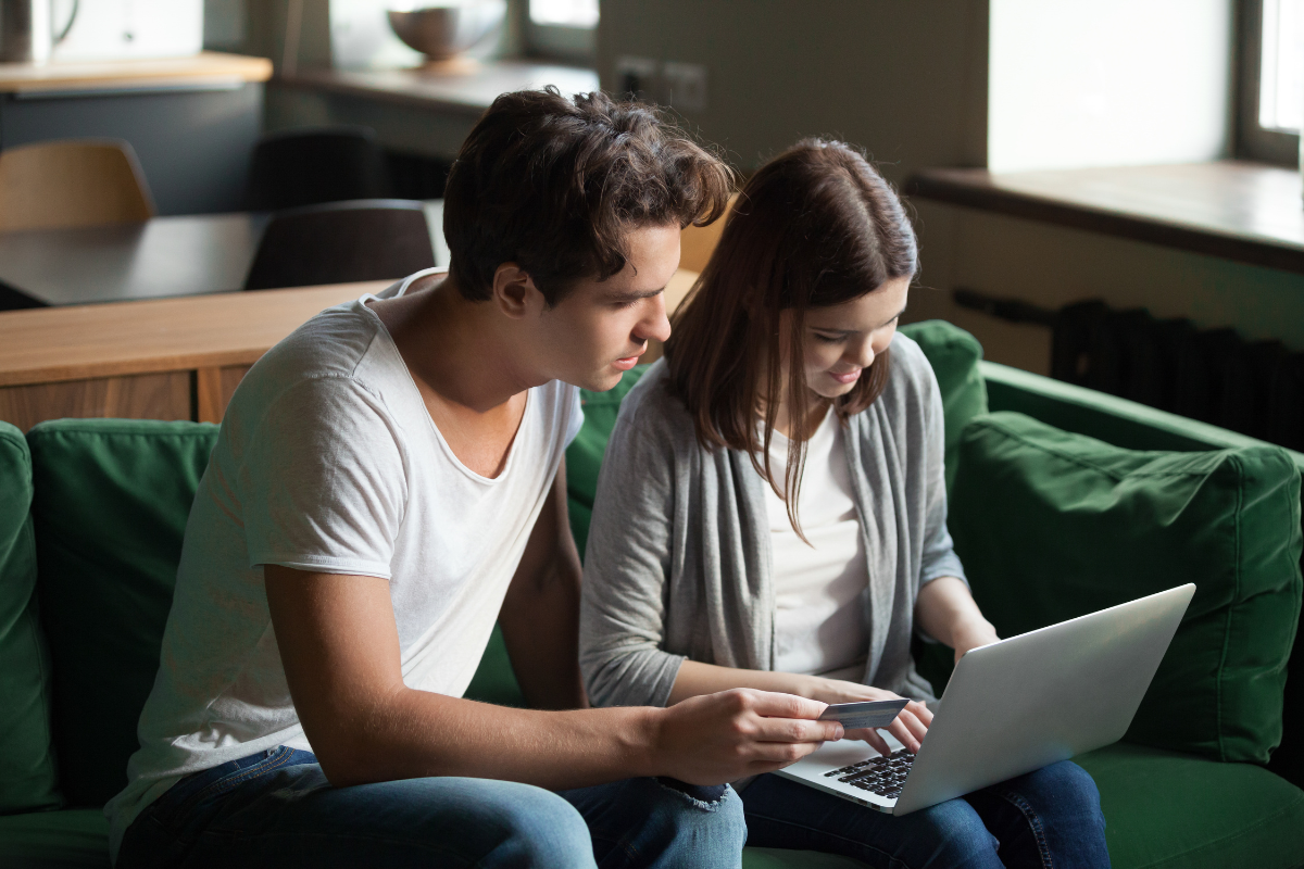 Casal de empresários lendo no notebook sobre: CertClick: o que é e como funciona nossa plataforma de certificados digitais.