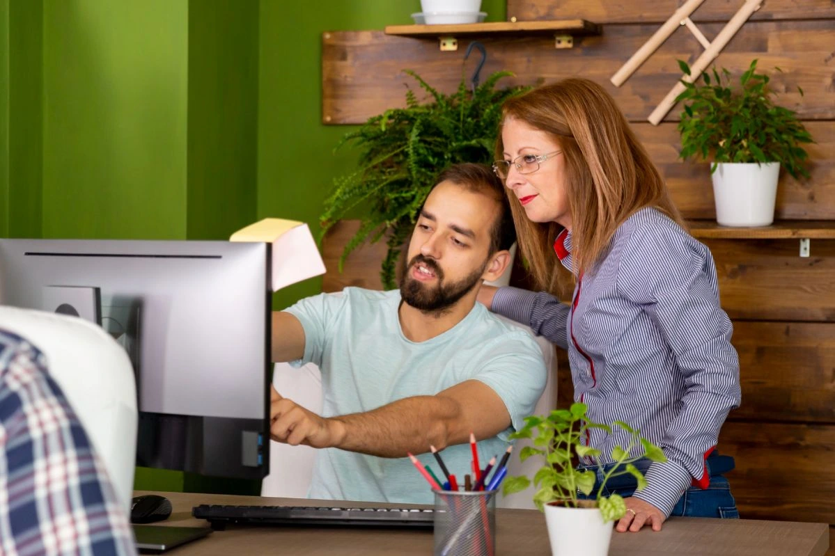 Casal de empreendedores lendo artigo no notebook sobre o que é criptografia e como ela protege seus dados online.