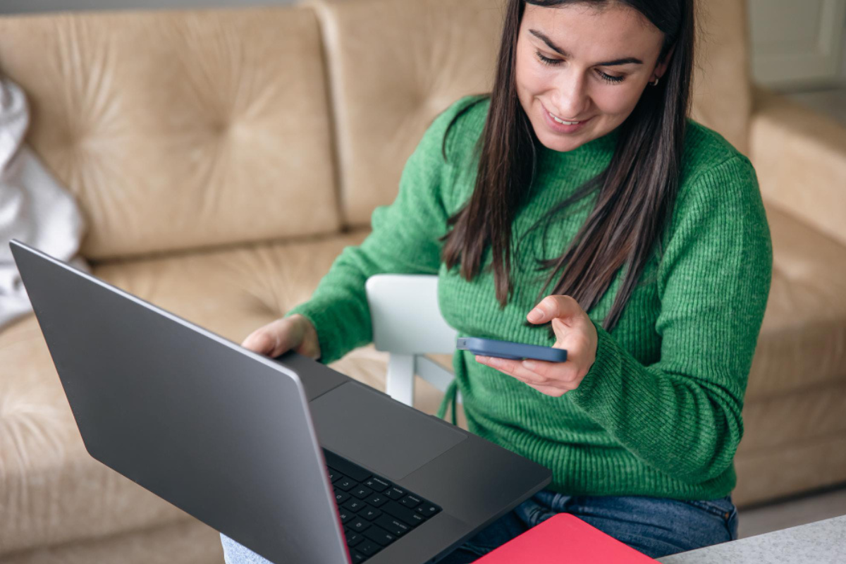Mulher sentado no sofá de sua sala de estar usando notebook no colo representando: Reforma Tributária e certificado digital: o que você precisa saber.