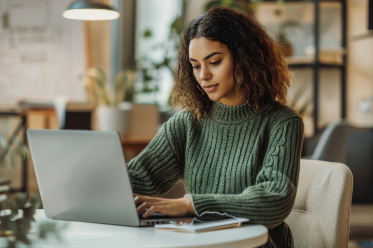 Mulher trabalhando em um notebook em ambiente de escritório representando: O que é débito tributário e como pagá-lo?