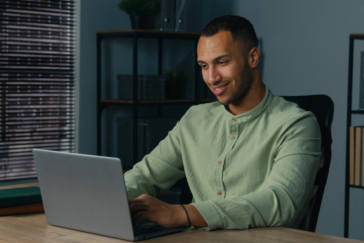 Homem usando notebook sobre uma mesa sentado em ambiente home office representando: Qual o uso do certificado digital na digitalização fiscal?