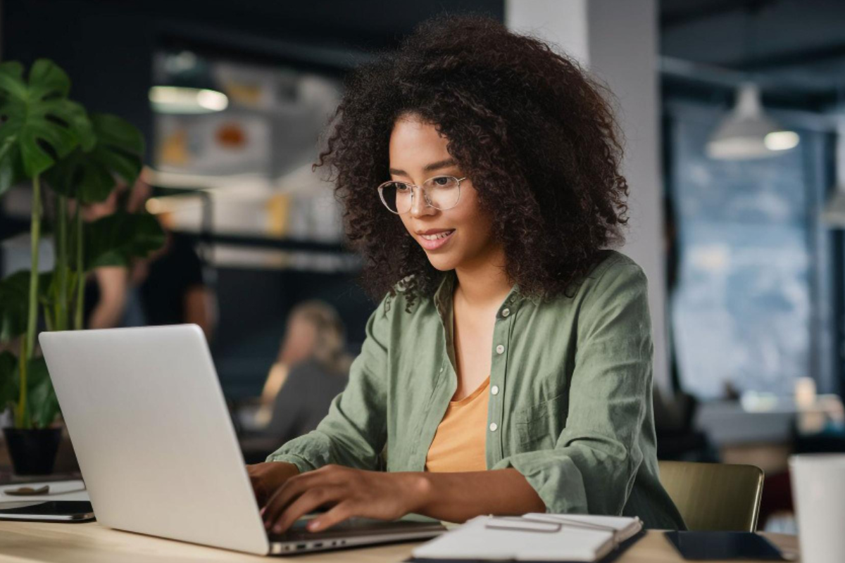 Mulher trabalhando em um notebook em ambiente de escritório representando: O que é a digitalização fiscal?