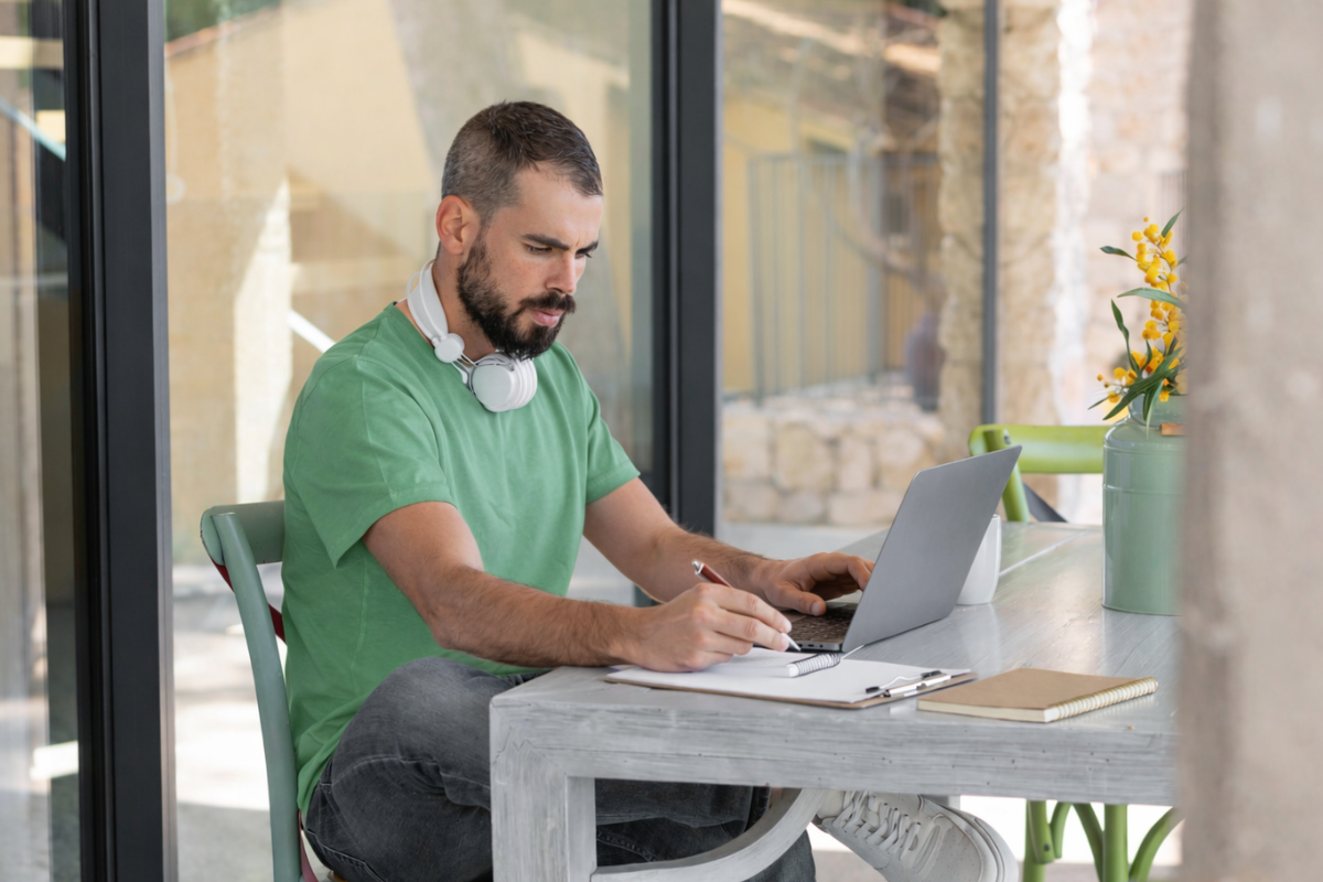 Homem usando notebook sobre uma mesa sentado em ambiente home office representando: Neutralidade fiscal na Reforma Tributária: o que é?