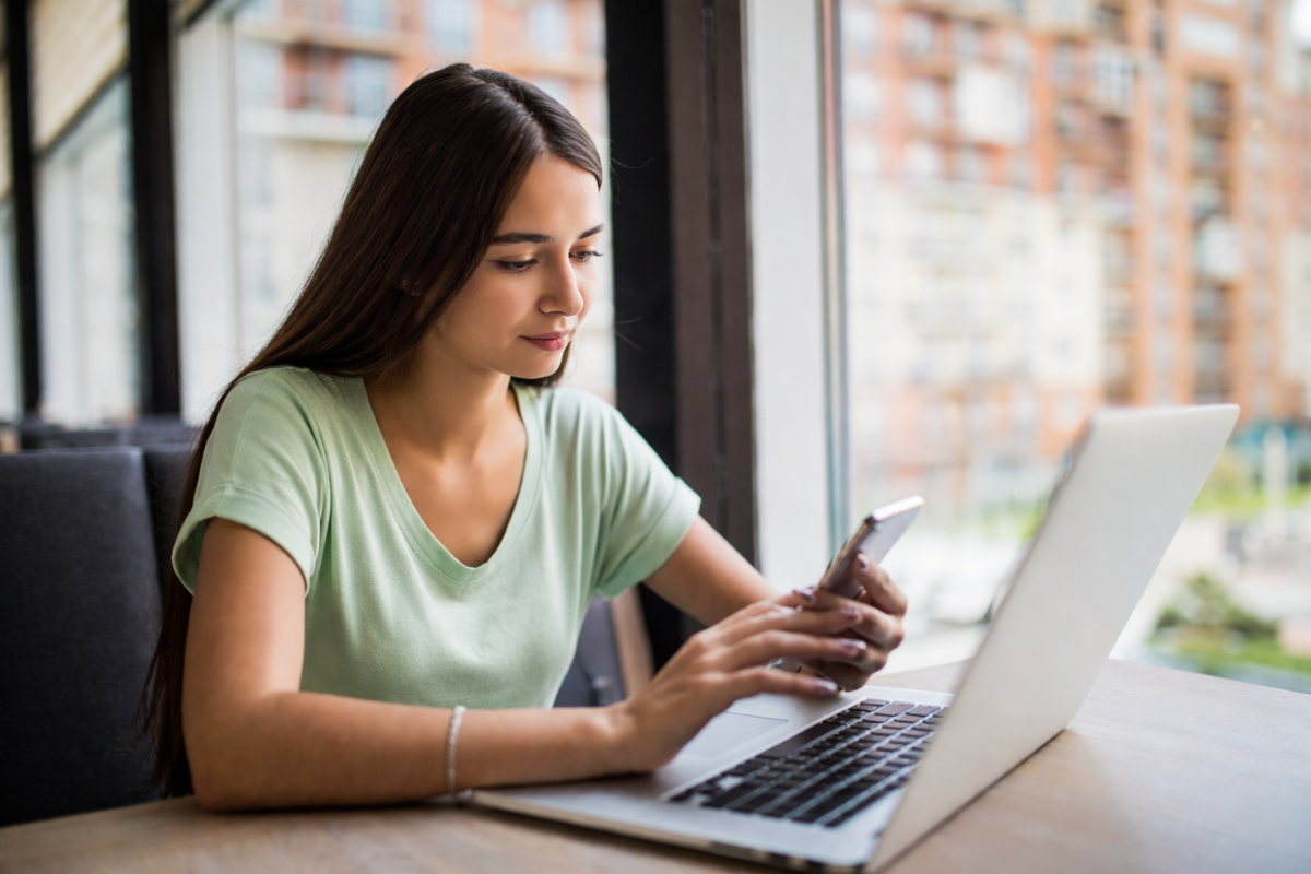 Mulher trabalhando em um notebook em ambiente de escritório representando: IBS e CBS: por que o novo sistema depende de certificação digital.