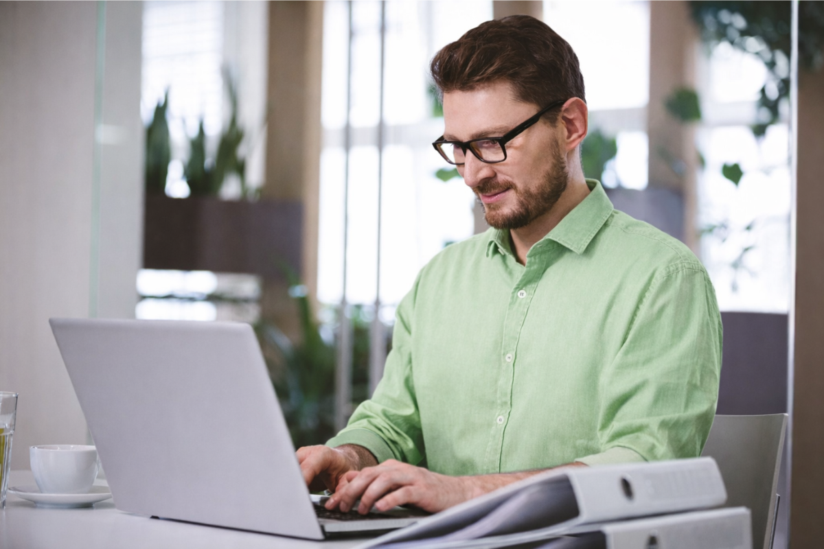 Homem usando notebook sobre uma mesa sentado em ambiente home office representando: Certificado digital em micro e pequenas empresas é obrigatório?