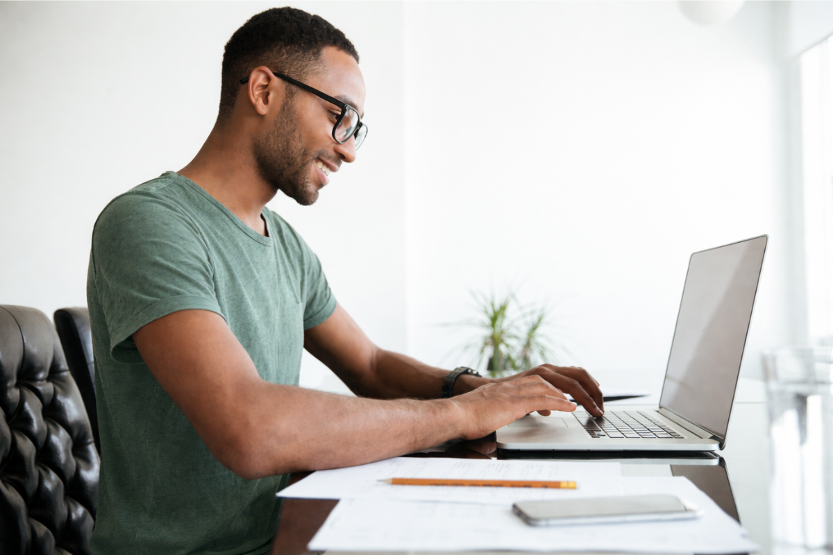 Homem usando notebook sobre uma mesa sentado em ambiente home office representando: Reforma tributária e previsibilidade: o sistema reduz litígios?