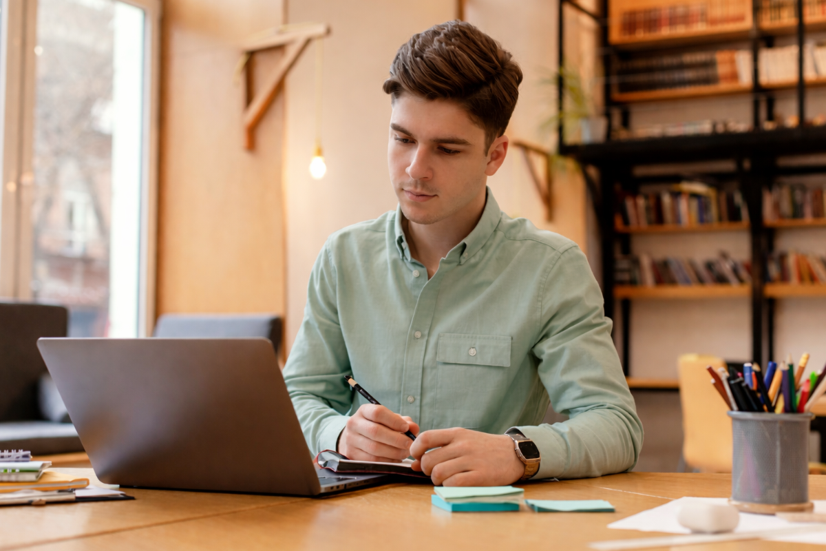 Homem usando notebook sobre uma mesa sentado em ambiente home office representando: Qual a relação entre obrigações acessórias e crédito tributário na Reforma Tributária?