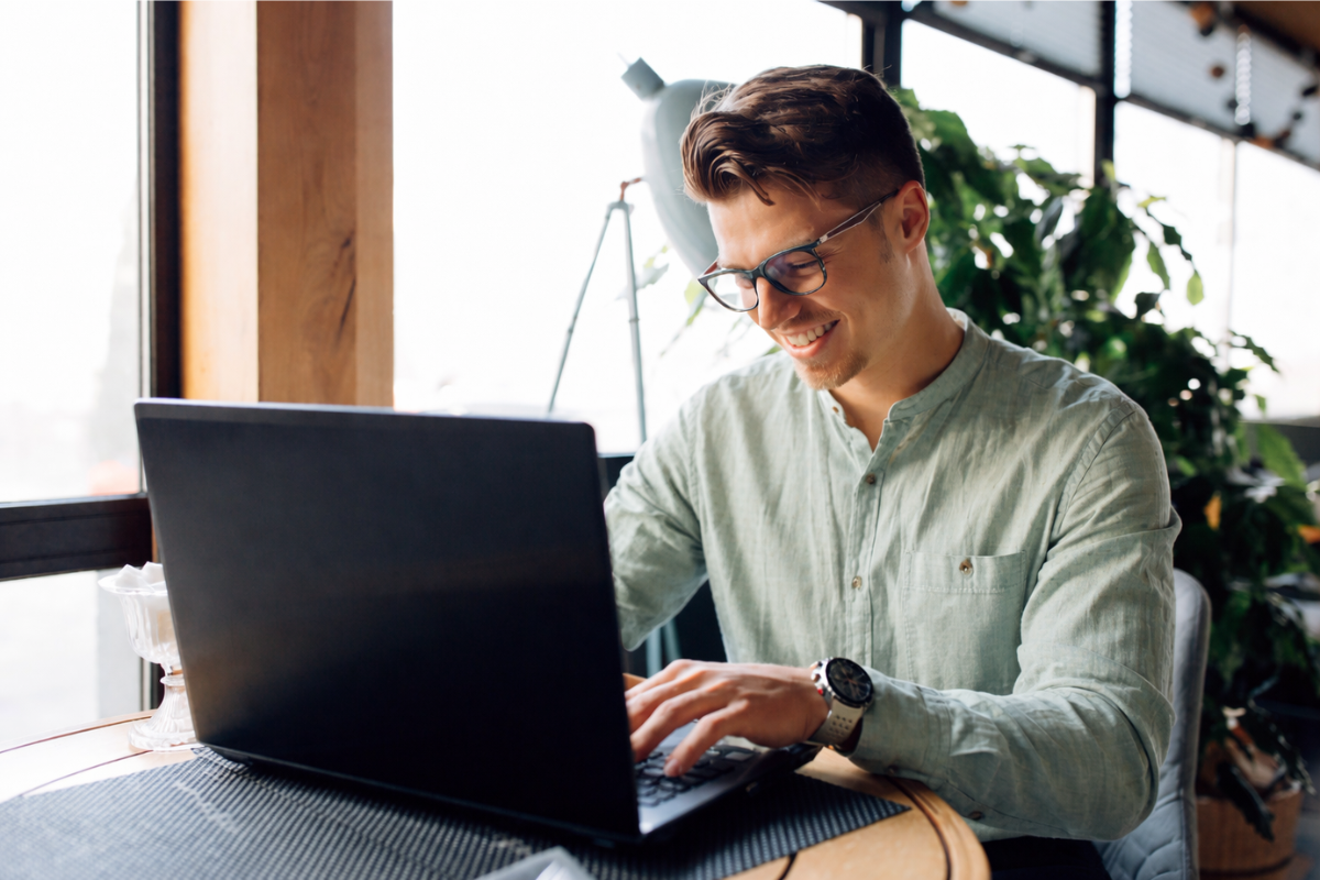 Homem usando notebook sobre uma mesa sentado em ambiente home office representando: Como evitar fraudes com certificado digital?